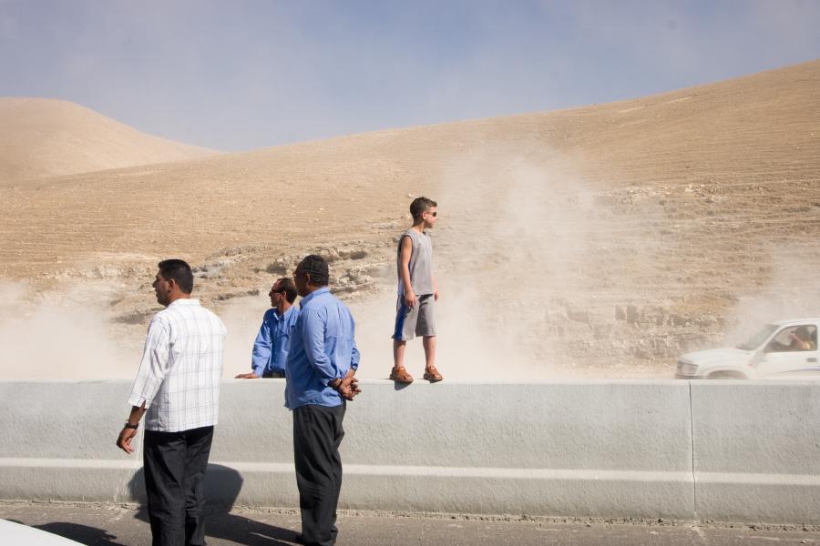 Men and a boy standing during a traffic jam east of Jerusalem